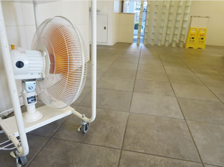 洗浄後の床面を送風機で乾燥